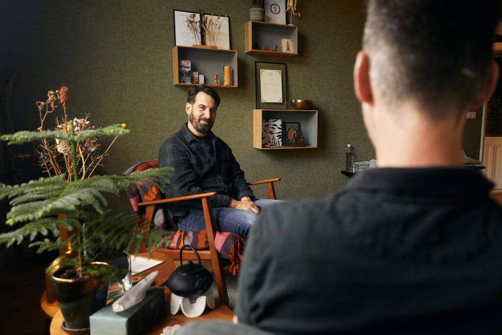 Therapeut Dennis in gesprek met een client tijdens een doorbraaksessie n zijn praktijk in Arnhem